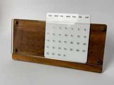 a wooden desk calendar with magnets attached to it