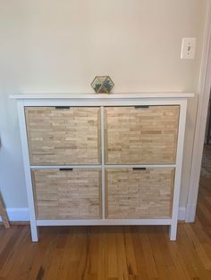 a white and wood dresser with four drawers