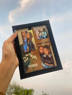 a person holding up a photo frame with pictures on it in front of the sky