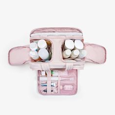 an open pink travel bag filled with makeup and toiletries on top of a white surface