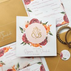 the wedding stationery is laid out on top of each other, including two rings