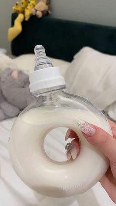 a person holding a baby bottle with a ring on the top and nail polish in it