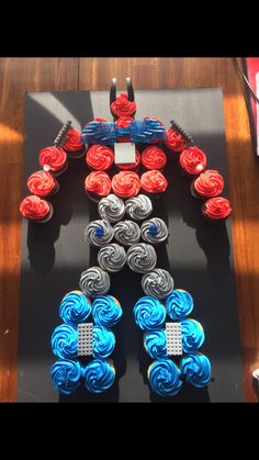 an iron man made out of cupcakes sitting on top of a wooden table