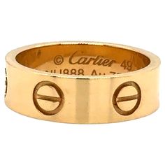 Cartier Love ring in 18K yellow gold. The ring is a size 49 U.S. size 4 3/4 with serial LNU---. Ring is fully hallmarked by designer "Cartier Au750 49 LNU---" Ring is in excellent condition and will arrive with original Cartier box & authentication papers. Width: 5.5mm. A child of 1970s New York, the LOVE collection remains today an iconic symbol of love that transgresses convention. The screw motifs, ideal oval shape and undeniable elegance establish the collection as a timeless tribute to passionate romance. Designer Yellow Gold Wedding Rings, Luxury Gold Rings With Certificate Of Authenticity, Gold Rings With Certificate Of Authenticity For Anniversary, Designer 14k Gold Round Rings, Designer 14k Gold Wedding Rings, Cartier Gold Rings Hallmarked, Designer Yellow Gold Anniversary Rings, Fine Jewelry Yellow Gold Rings, Designer Yellow Gold Rings For Anniversary