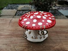 a red and white mushroom sitting on top of a wooden table