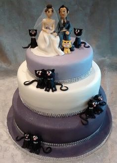 a wedding cake with cats on top