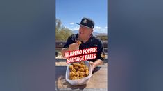 a man sitting at a table eating food with a sign reading jalapeno popper sunrise balls