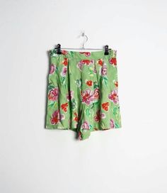 "a vintage pair of high-waisted green and pink floral pattern shorts with buttons all the way up the left side ✿ IMPORTANT INFORMATION: * excellent vintage condition * material: 100% viscose * size: small - please check exact measurements below (they're there for your benefit!) * garment care: machine washable * made in belgium ✿ MEASUREMENTS (taken while item is lying flat, some measurements will need to be doubled): * waist: 14\" (36cm) * hips: 25\" (64cm) * front rise: 14.5\" (37cm) * back ri Green Knee-length Shorts For Vacation, Fitted Floral Print Shorts, Retro Floral Print Short Bottoms, Green Summer Pajama Shorts, Vintage Shorts With Built-in Shorts For Spring, High Waist Green Shorts For Summer, Green Floral Print Short Bottoms, Vintage Floral Print Bottoms For Spring, Green High-waisted Summer Pajama Shorts