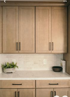 a kitchen with wooden cabinets and white counter tops