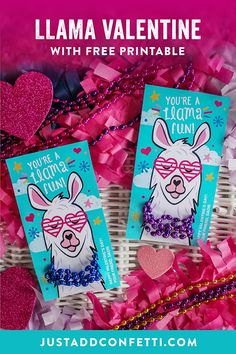 two llama valentine's day cards sitting on top of pink and purple streamers