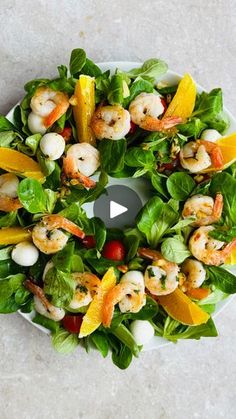 a salad with shrimp and lettuce on top is shown in the middle of a video