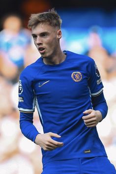 a young man in blue soccer uniform on the field