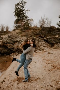 two people hugging each other on the beach