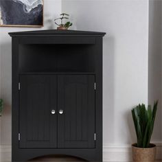 a black cabinet with two doors on the front and one door open to reveal a potted plant