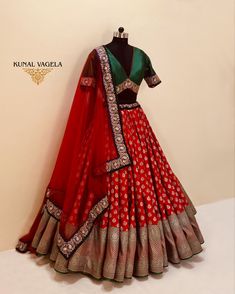 a red and gold lehenga is displayed on a mannequin