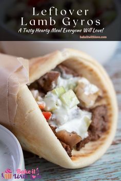 a pita filled with meat and vegetables on top of a wooden table