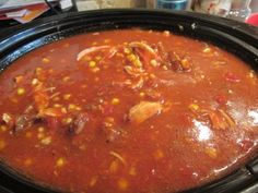 a pot filled with chili and corn on top of a stove