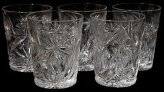 four clear glass tumblers on a black background