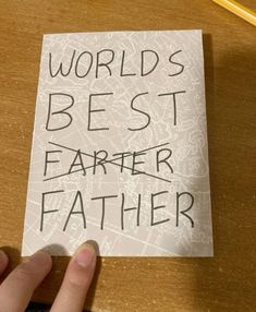 a person holding up a piece of paper with the words world's best father written on it