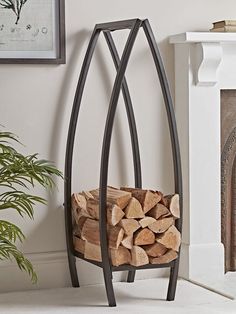 a stack of firewood in front of a fireplace with a potted plant next to it