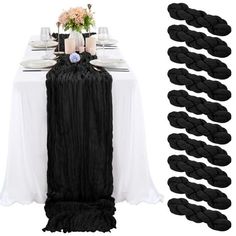 the table is set with black and white linens, flowers and candles on it