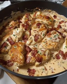 a pan filled with chicken covered in gravy and bacon