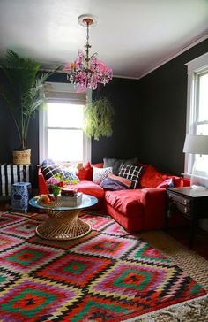 a living room filled with lots of furniture and a chandelier hanging from the ceiling