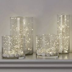 three glass vases with lights in them on a shelf