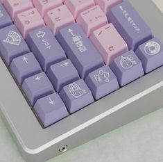 a computer keyboard with different colored keys and symbols on the key board, sitting on a white surface