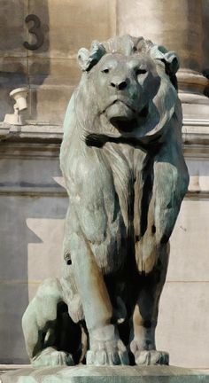 a statue of a lion is shown in front of a building