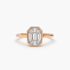 an emerald - cut diamond engagement ring in yellow gold