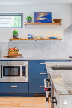 a kitchen with blue cabinets and stainless steel appliances, including a built - in microwave