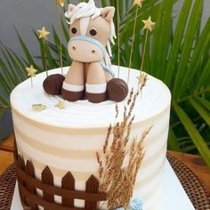 a birthday cake with a horse sitting on it's side and stars around the top