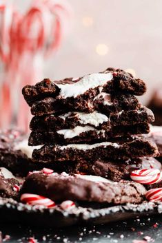 a pile of chocolate cookies with white frosting and candy canes