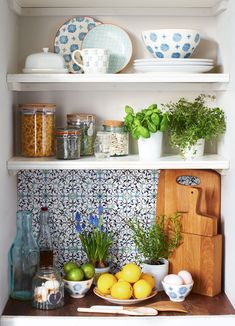 the shelves in this kitchen are filled with plates, bowls and other things to eat