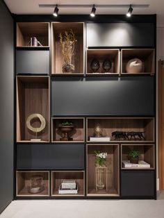 the shelves are filled with vases, books and other decorative items in black and brown