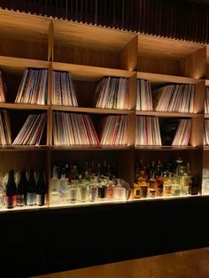 the shelves are filled with various types of records and liquors on display in front of them