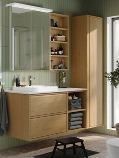 a bathroom with a sink, mirror and shelves filled with towels on the counter top