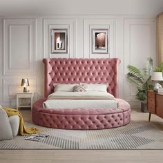 a pink bed in a white room with pictures on the wall