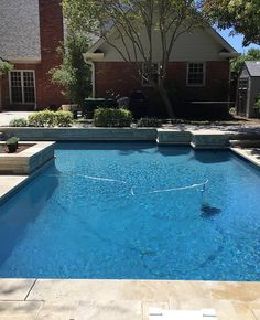 an empty swimming pool in front of a house