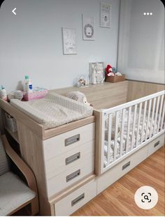 a baby crib in a room with wooden floors and white furniture on the walls