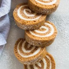 several cinnamon roll cookies stacked on top of each other with icing and powdered sugar