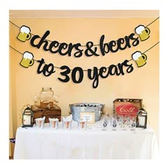 a table topped with lots of bottles and glasses next to a sign that says cheers to 30 years