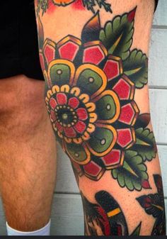 a man's leg with tattoos on it and flowers in the middle of his legs