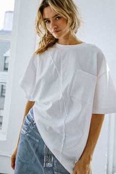 Short sleeve, solid knit top, featuring round neckline and asymmetrical hemline. Available in white and taupe. 100% Cotton