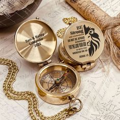 two gold pocket watches sitting on top of a map