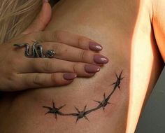 a woman's stomach with barbed wire tattoos on it