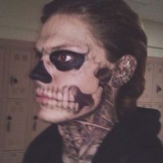 a woman with makeup and skeleton make up on her face