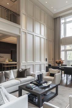 a living room filled with white furniture and lots of windows