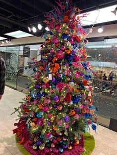 a brightly colored christmas tree with ornaments on it